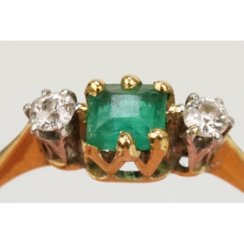 64 - 18ct gold diamond and emerald three stone ring. The ring being set with a square step cut emerald fl... 