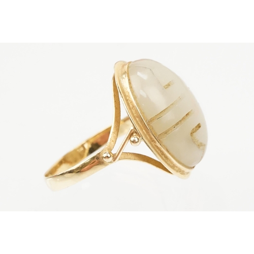 73 - 18ct gold and jade ring. The ring being set with an oval carved jade panel with pierced detailing. M... 