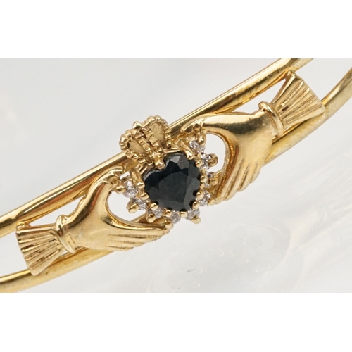 74 - 9ct gold Claddagh bangle bracelet being set with a heart cut blue stone to centre with cz accent sto... 