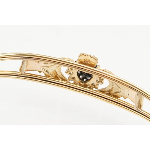 74 - 9ct gold Claddagh bangle bracelet being set with a heart cut blue stone to centre with cz accent sto... 