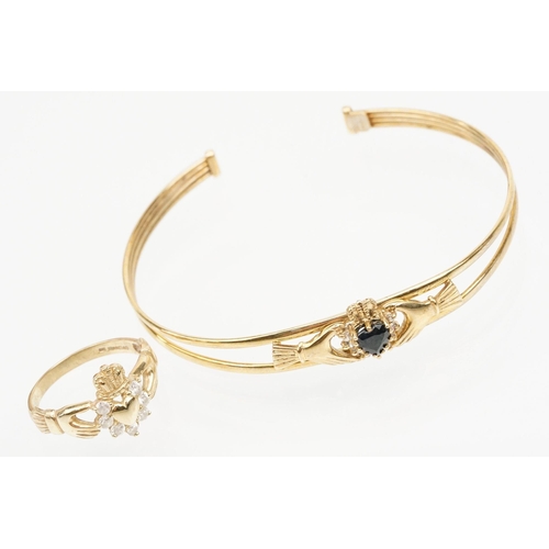 74 - 9ct gold Claddagh bangle bracelet being set with a heart cut blue stone to centre with cz accent sto... 