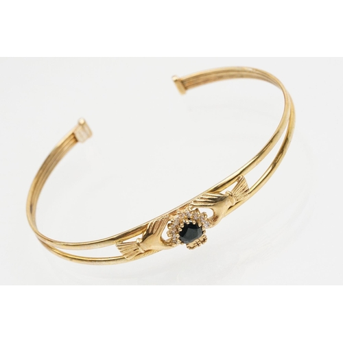 74 - 9ct gold Claddagh bangle bracelet being set with a heart cut blue stone to centre with cz accent sto... 