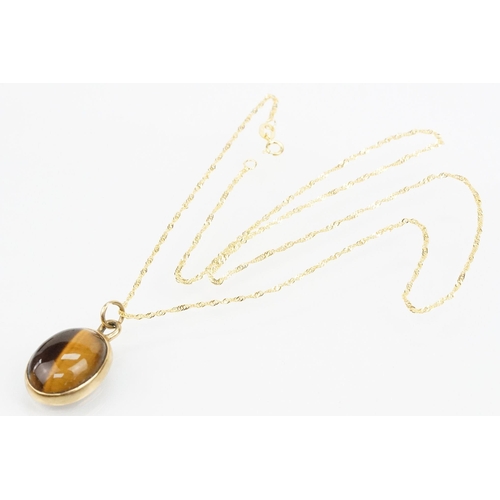 112 - 9ct gold and tigers eye set ring and necklace. The ring being set with an oval tigers eye cabochon (... 