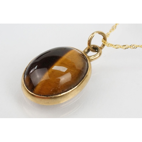 112 - 9ct gold and tigers eye set ring and necklace. The ring being set with an oval tigers eye cabochon (... 