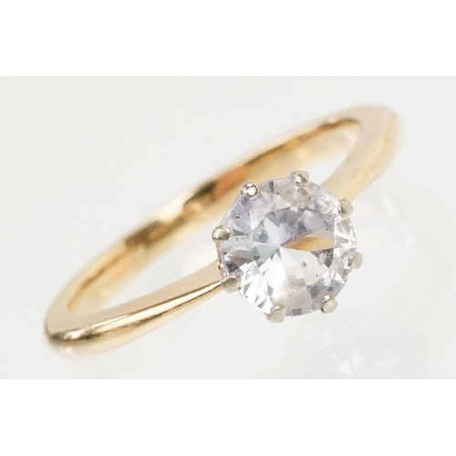 168 - White sapphire solitaire ring being set with a round brilliant cut sapphire in a prong setting on a ... 