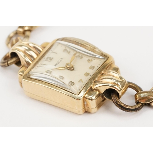 322 - 9ct gold Ravella wrist watch having a square face on a gold plated strap. Case measures approx 15mm ... 