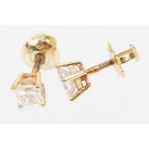 34 - Pair of 14ct gold and diamond stud earrings. Each earring set with a square princess cut diamond in ... 