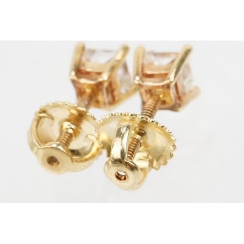 34 - Pair of 14ct gold and diamond stud earrings. Each earring set with a square princess cut diamond in ... 