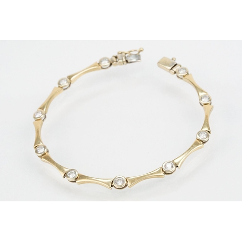 45 - 14ct gold and cz line bracelet being bezel set with round cut cz's with spacer links. Marked 585 to ... 