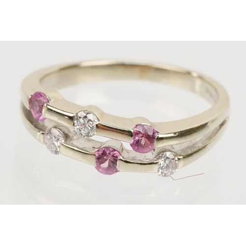 51 - 18ct white gold diamond and pink sapphire ring. The ring having a split band channel set with three ... 