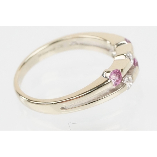 51 - 18ct white gold diamond and pink sapphire ring. The ring having a split band channel set with three ... 