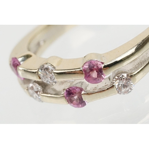 51 - 18ct white gold diamond and pink sapphire ring. The ring having a split band channel set with three ... 