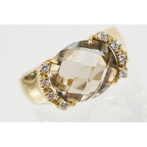 56 - 18ct gold, smoky quartz and diamond ring. The ring being set with an oval faceted smoky quartz flank... 