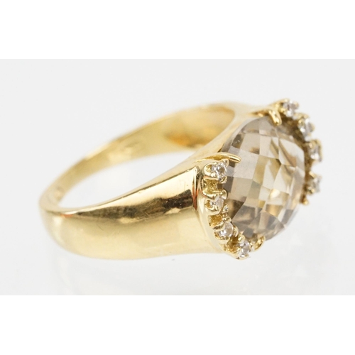 56 - 18ct gold, smoky quartz and diamond ring. The ring being set with an oval faceted smoky quartz flank... 