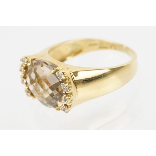 56 - 18ct gold, smoky quartz and diamond ring. The ring being set with an oval faceted smoky quartz flank... 