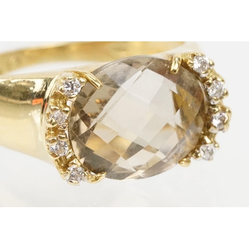 56 - 18ct gold, smoky quartz and diamond ring. The ring being set with an oval faceted smoky quartz flank... 