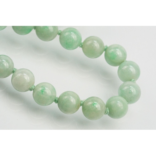 16 - Jade beaded necklace threaded with green jadeite spherical beads with a 9ct gold clasp. Measures 15 ... 