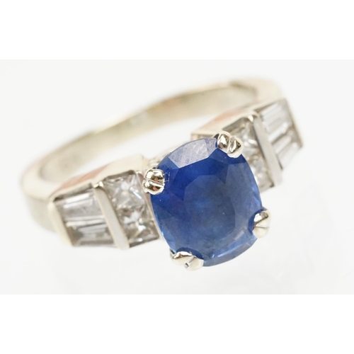 2 - 18ct white gold, sapphire and diamond ring. The ring being set with an oval mixed cut blue sapphire ... 