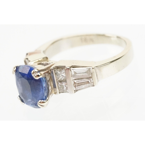 2 - 18ct white gold, sapphire and diamond ring. The ring being set with an oval mixed cut blue sapphire ... 