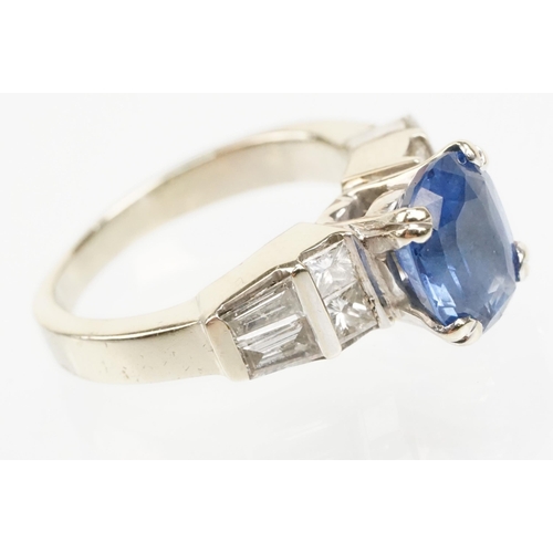 2 - 18ct white gold, sapphire and diamond ring. The ring being set with an oval mixed cut blue sapphire ... 