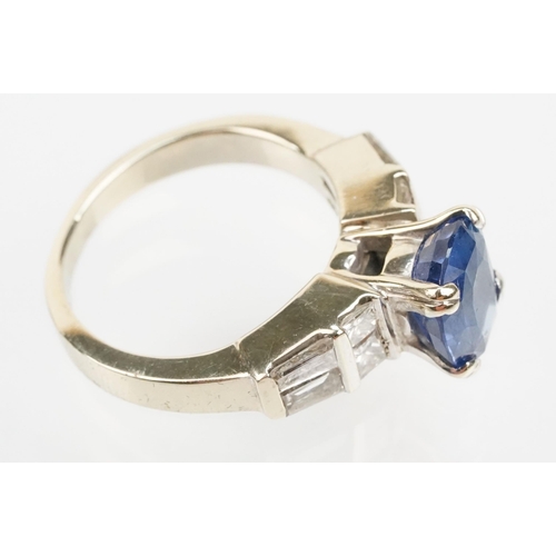 2 - 18ct white gold, sapphire and diamond ring. The ring being set with an oval mixed cut blue sapphire ... 