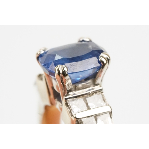 2 - 18ct white gold, sapphire and diamond ring. The ring being set with an oval mixed cut blue sapphire ... 