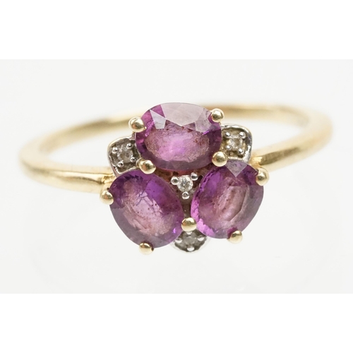 249 - 9ct gold Comeria garnet and diamond cluster ring. The ring being set with three oval cut purple garn... 