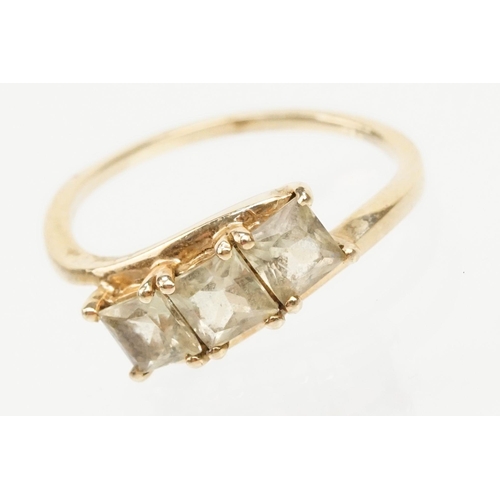 251 - 9ct gold and Csarite three stone ring. The ring  being set with three square mixed cut stones in a c... 