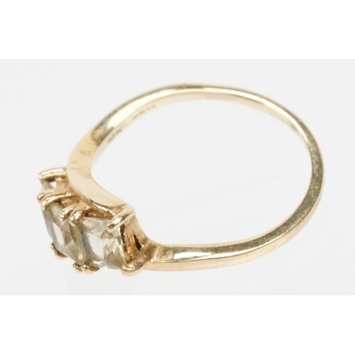 251 - 9ct gold and Csarite three stone ring. The ring  being set with three square mixed cut stones in a c... 