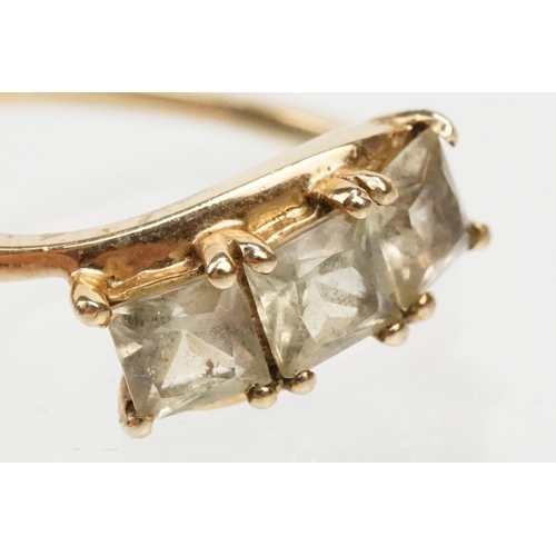 251 - 9ct gold and Csarite three stone ring. The ring  being set with three square mixed cut stones in a c... 