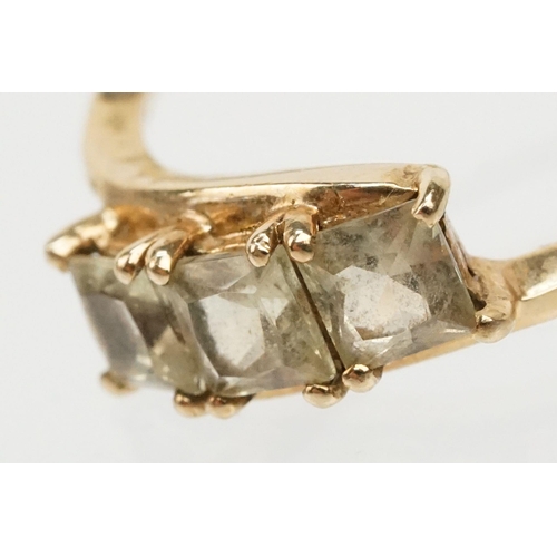 251 - 9ct gold and Csarite three stone ring. The ring  being set with three square mixed cut stones in a c... 