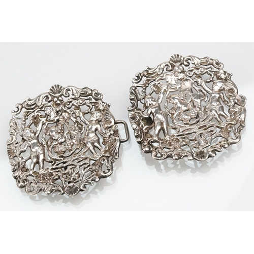 271 - Two silver nurses belt buckles to include an example featuring classical cherubs with grape vines an... 