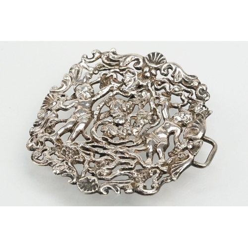 271 - Two silver nurses belt buckles to include an example featuring classical cherubs with grape vines an... 