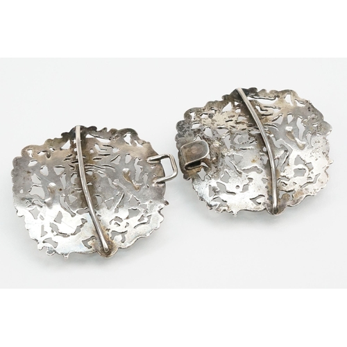 271 - Two silver nurses belt buckles to include an example featuring classical cherubs with grape vines an... 