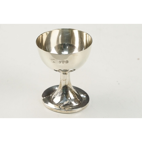 360 - Collection of silver items to include an egg cup, small chamberstick, napkin ring, and jar lid. All ... 