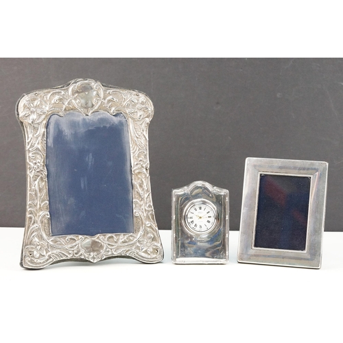 380 - Two silver hallmarked photo frames and a R Carr silver fronted clock. To include a floral fronted fr... 