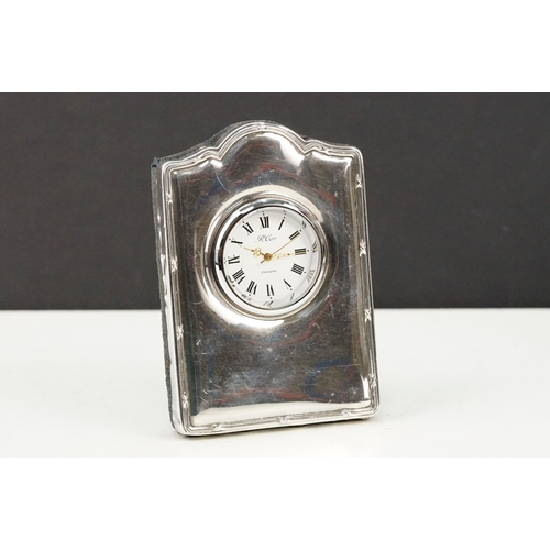 380 - Two silver hallmarked photo frames and a R Carr silver fronted clock. To include a floral fronted fr... 