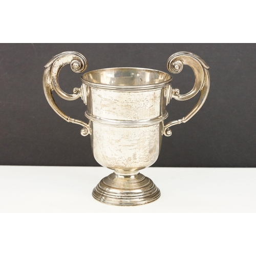 387 - Early 20th Century silver twin handled trophy cup. The cup having scrolled twin handled raised on a ... 