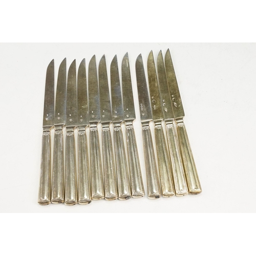 392 - Set of twelve early 20th Century French silver fruit knives, each with engraved crests to the handle... 