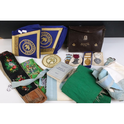 131 - A collection of masonic collectables to include jewels, sashes, books and associated regalia.