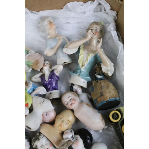 139 - A large collection of antique ceramic pin cushion dolls and doll heads of various sizes and styles.