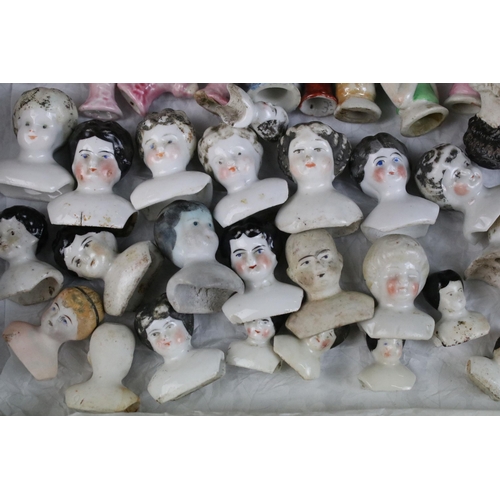 139 - A large collection of antique ceramic pin cushion dolls and doll heads of various sizes and styles.