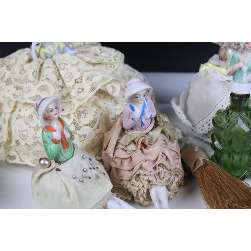 139 - A large collection of antique ceramic pin cushion dolls and doll heads of various sizes and styles.