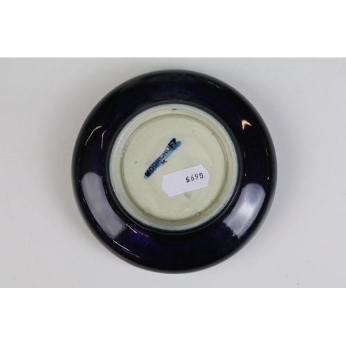 26 - Moorcroft inverted rim dish ashtray, diameter 11.5cm together with a pair of miniature porcelain dol... 