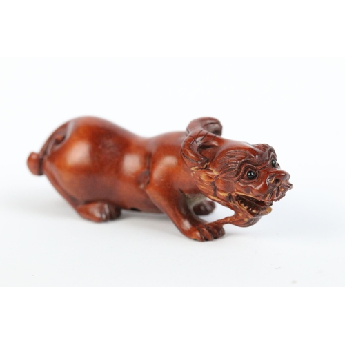 101 - Two carved wooden netsuke figures of a Chinese dragon to include one eating fruit