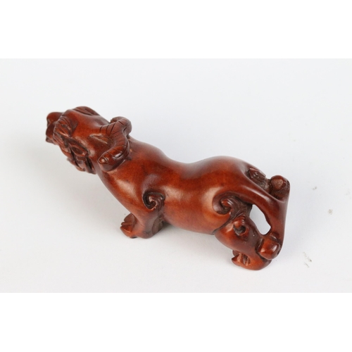 101 - Two carved wooden netsuke figures of a Chinese dragon to include one eating fruit