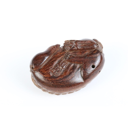 101 - Two carved wooden netsuke figures of a Chinese dragon to include one eating fruit