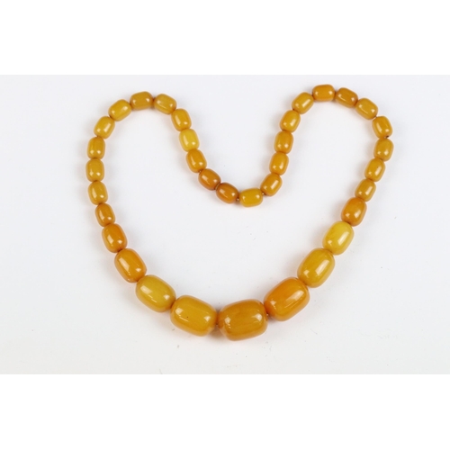 106A - An amber style beaded necklace with beads of cylindrical form.