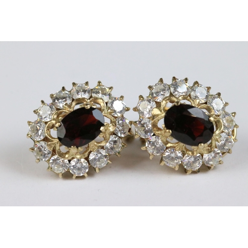 110 - A pair of ladies hallmarked 9ct gold earrings with central red stones.