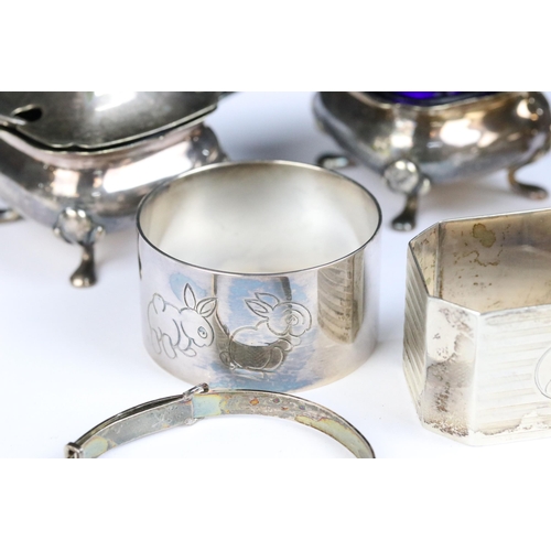 115 - A collection of hallmarked sterling silver to include cruet set, napkin rings and silver bangles.